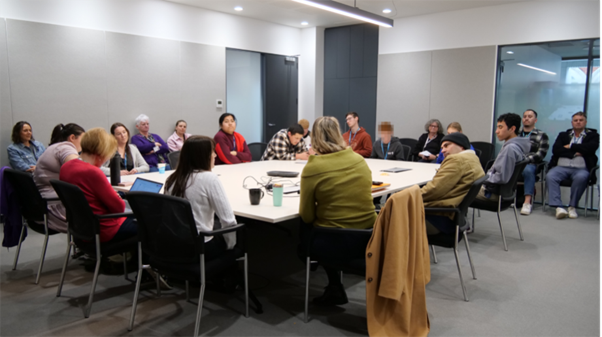A group of people sitting around a boardroom table.