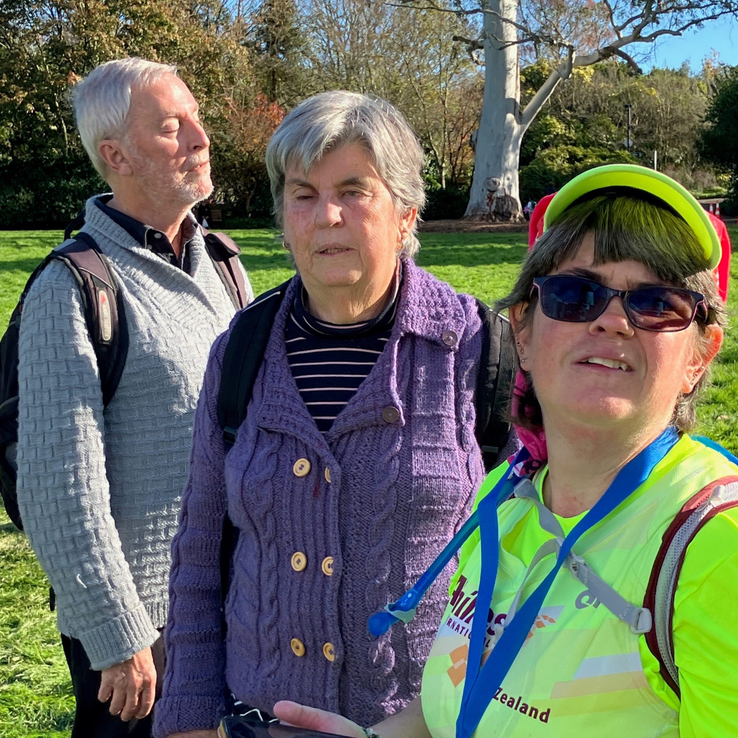 A man and two women outdoors on a sunny day.