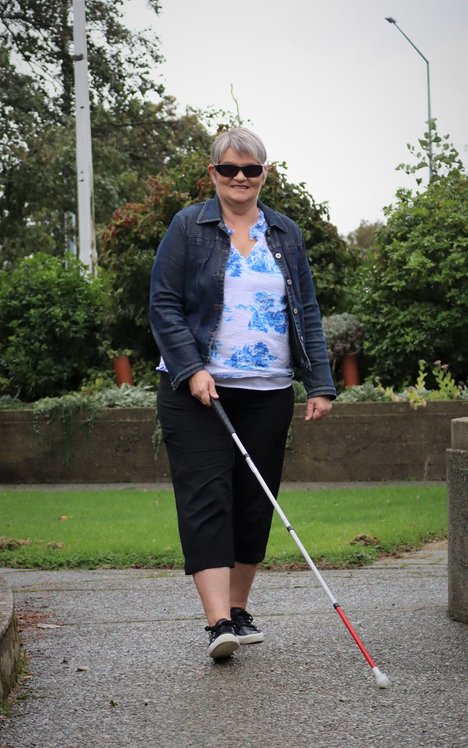 A client walking confidently with a white cane.